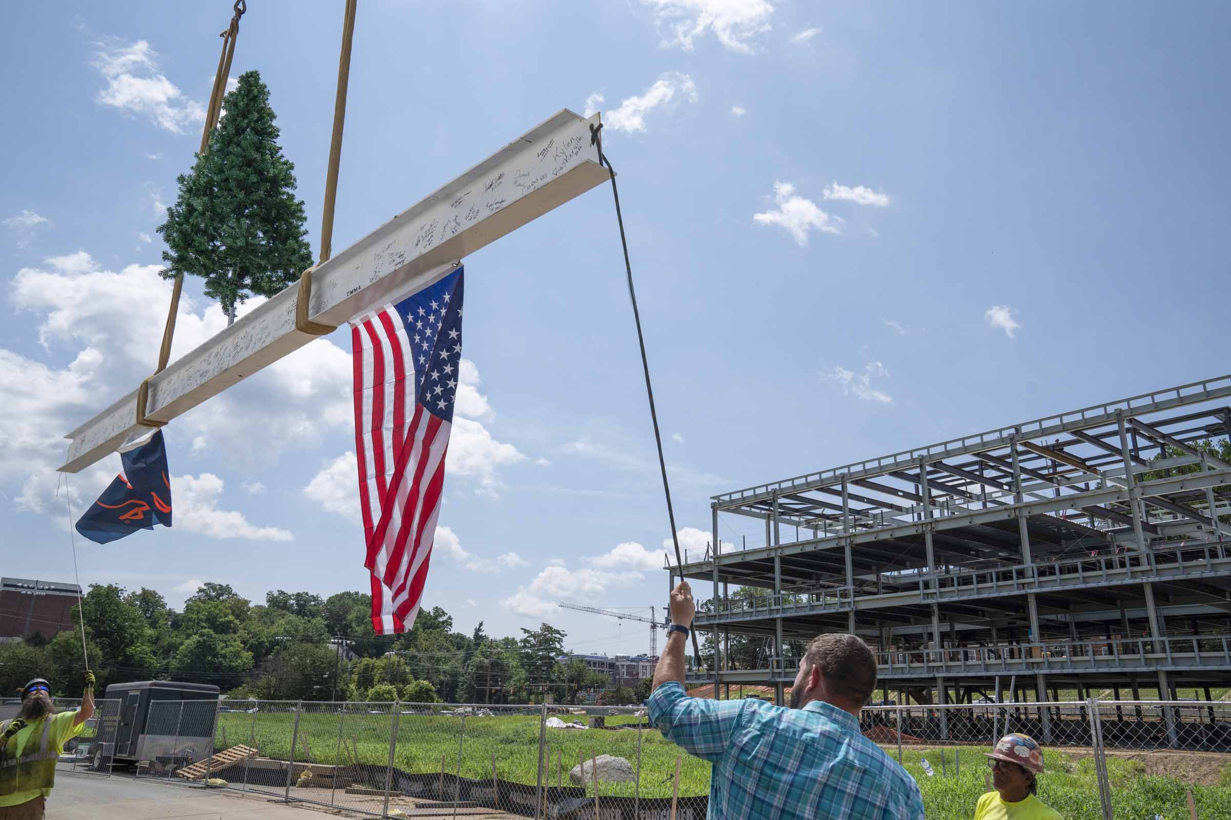 Raising the final steel beam over the School of Data Science building construction.