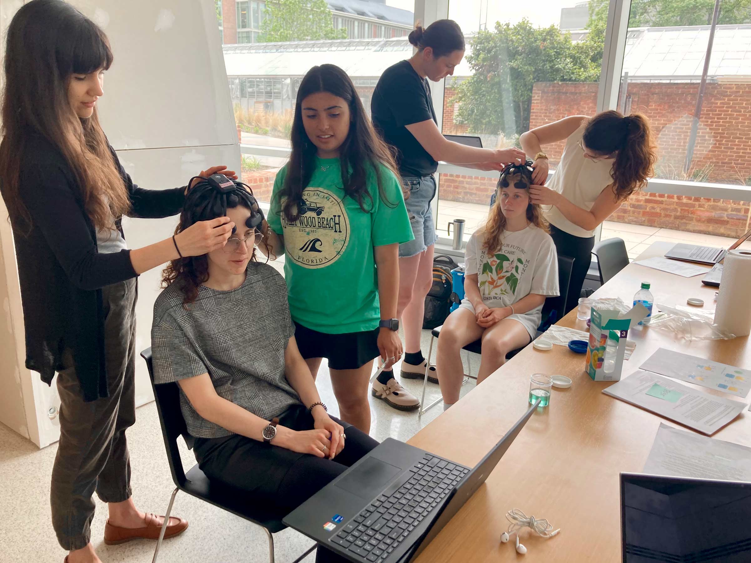 Julie Mollica, Analia Mazoratti, Margaret Saunders and Gabby Snetkov attach sensors to participants in the study. The sensors helped measure participants' reactions to the different chambers. 