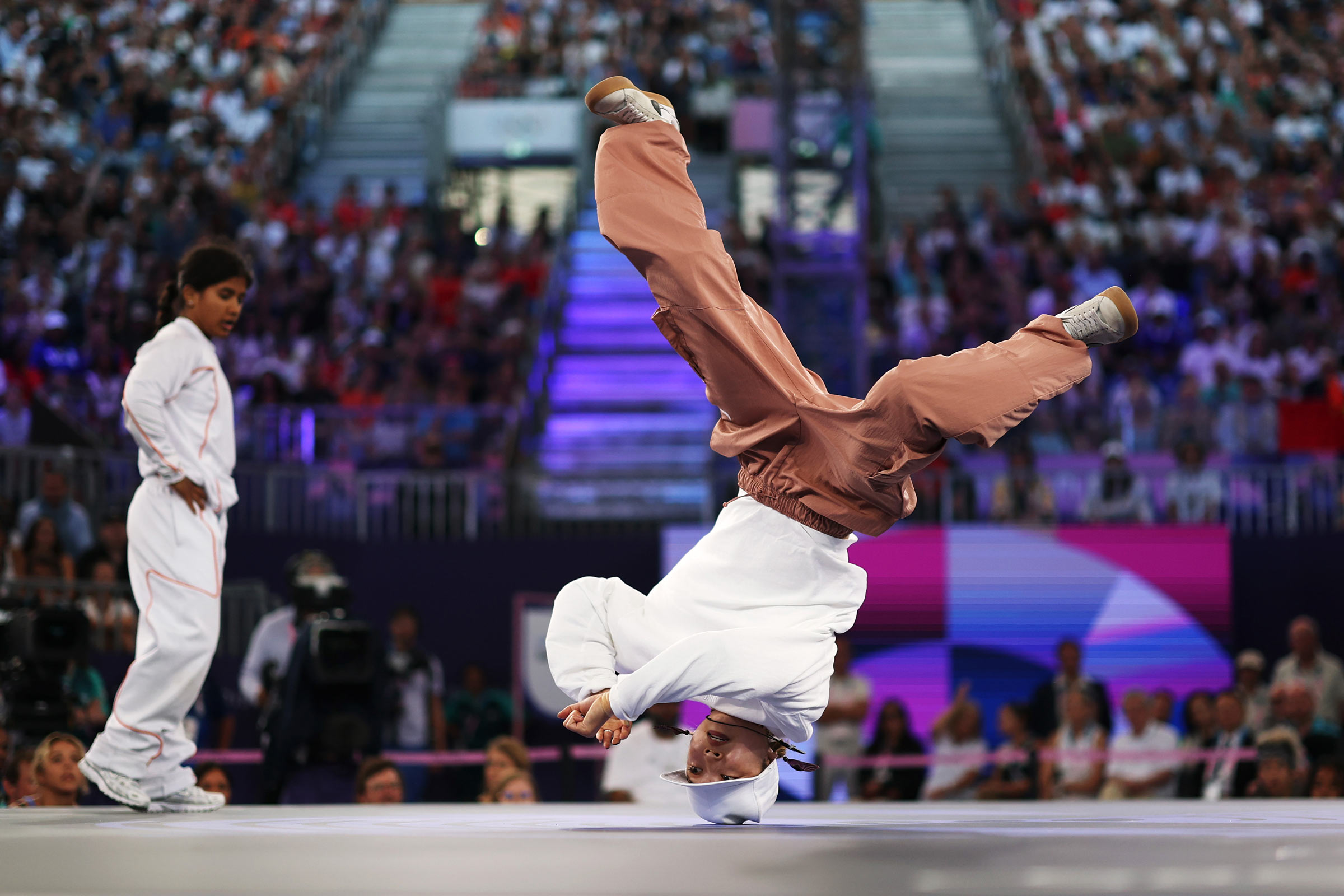 Candid photo of a breakdancer performing in front of an audience.