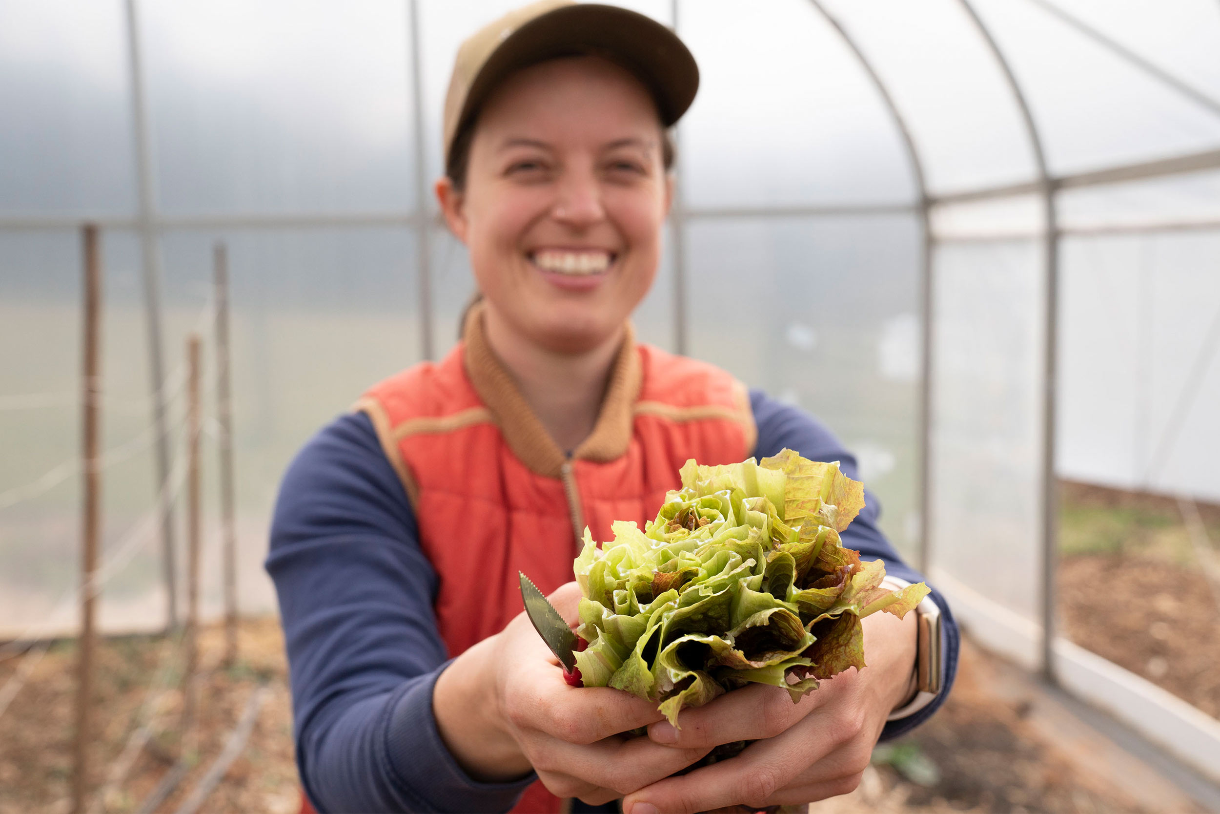 Fiona Flynn holding up a handful of fresh cut lettuce