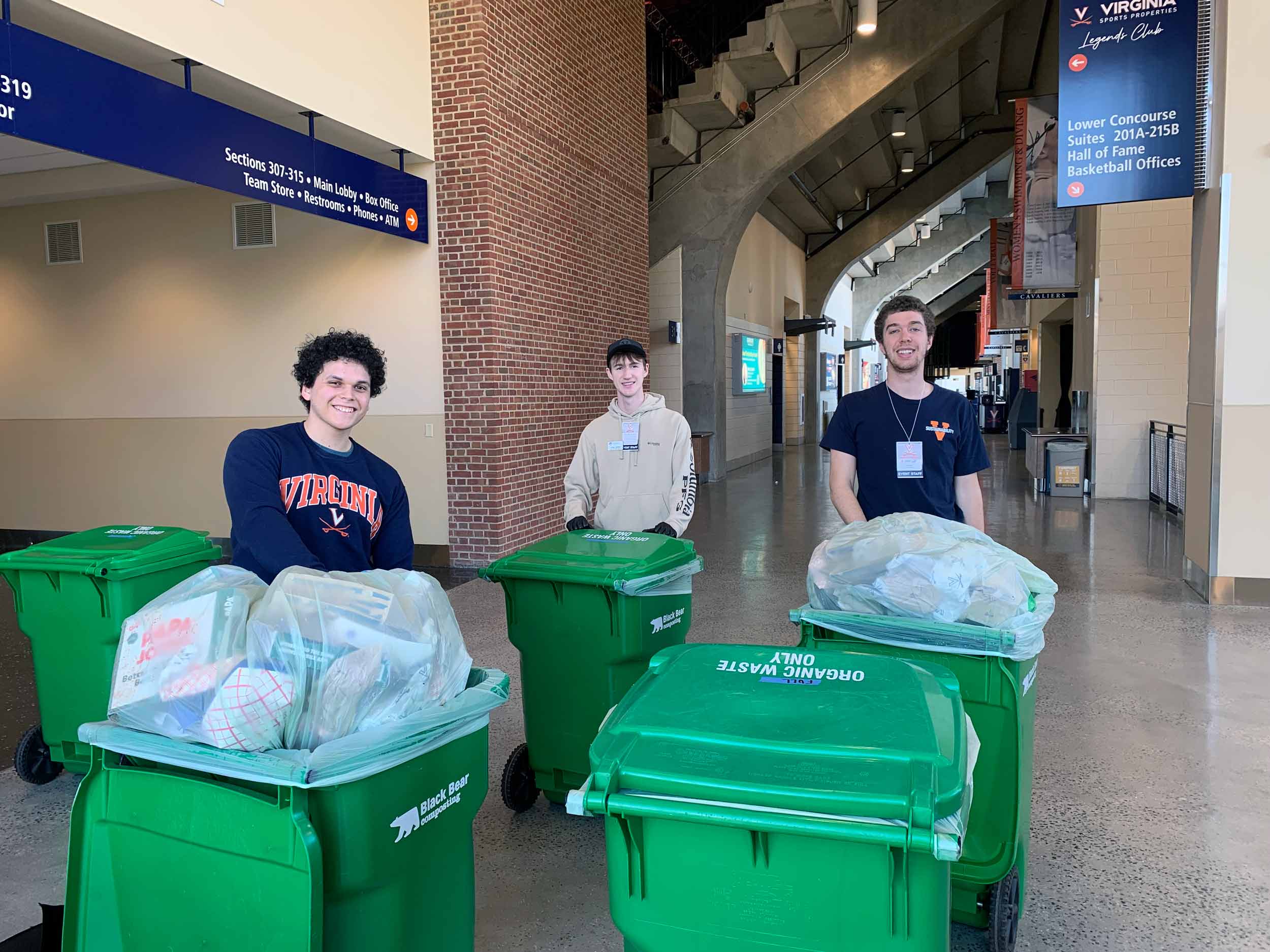 Students hauling compostable waste in John Paul Jones Arena
