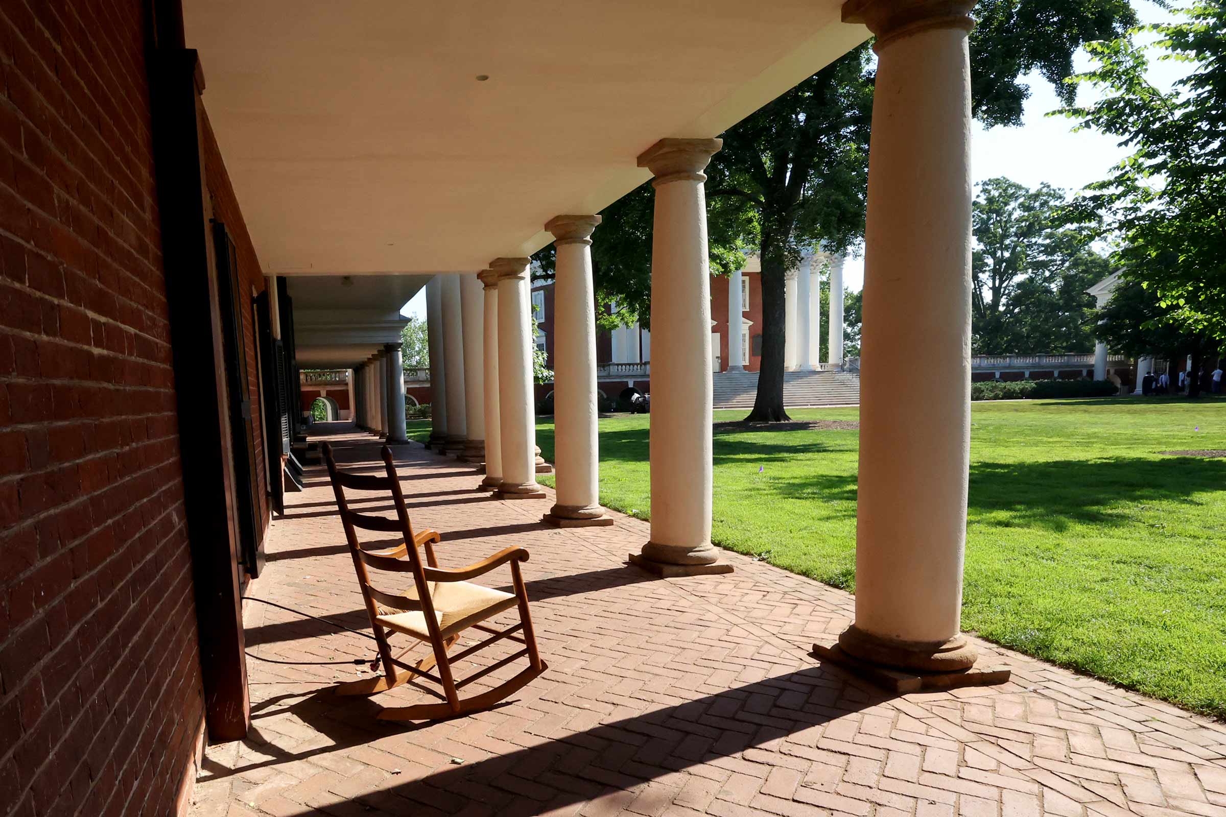 A lone rocking chair sits behind the columns on the Lawn.