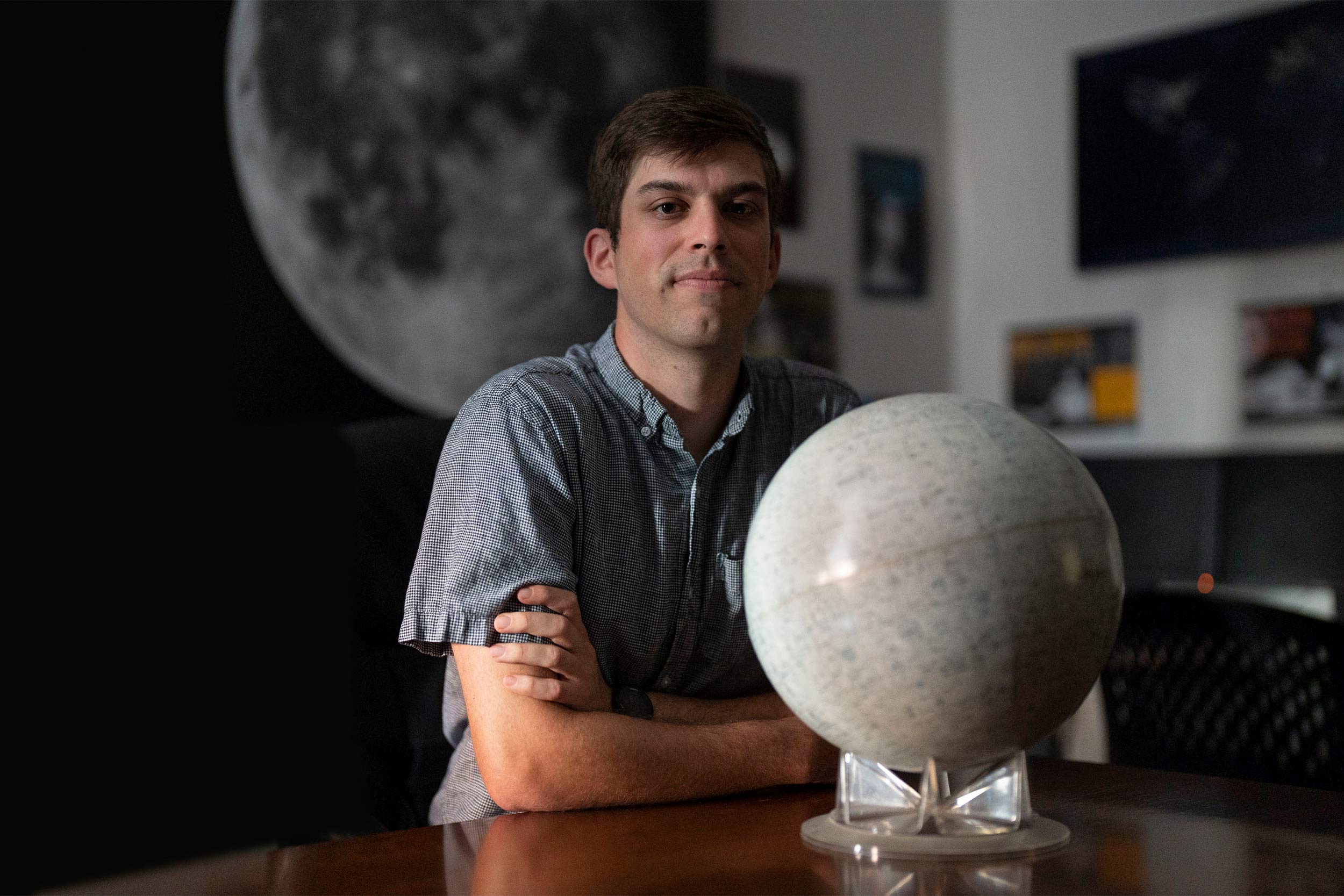 Portrait of Matt Pryal with a globe of the moon
