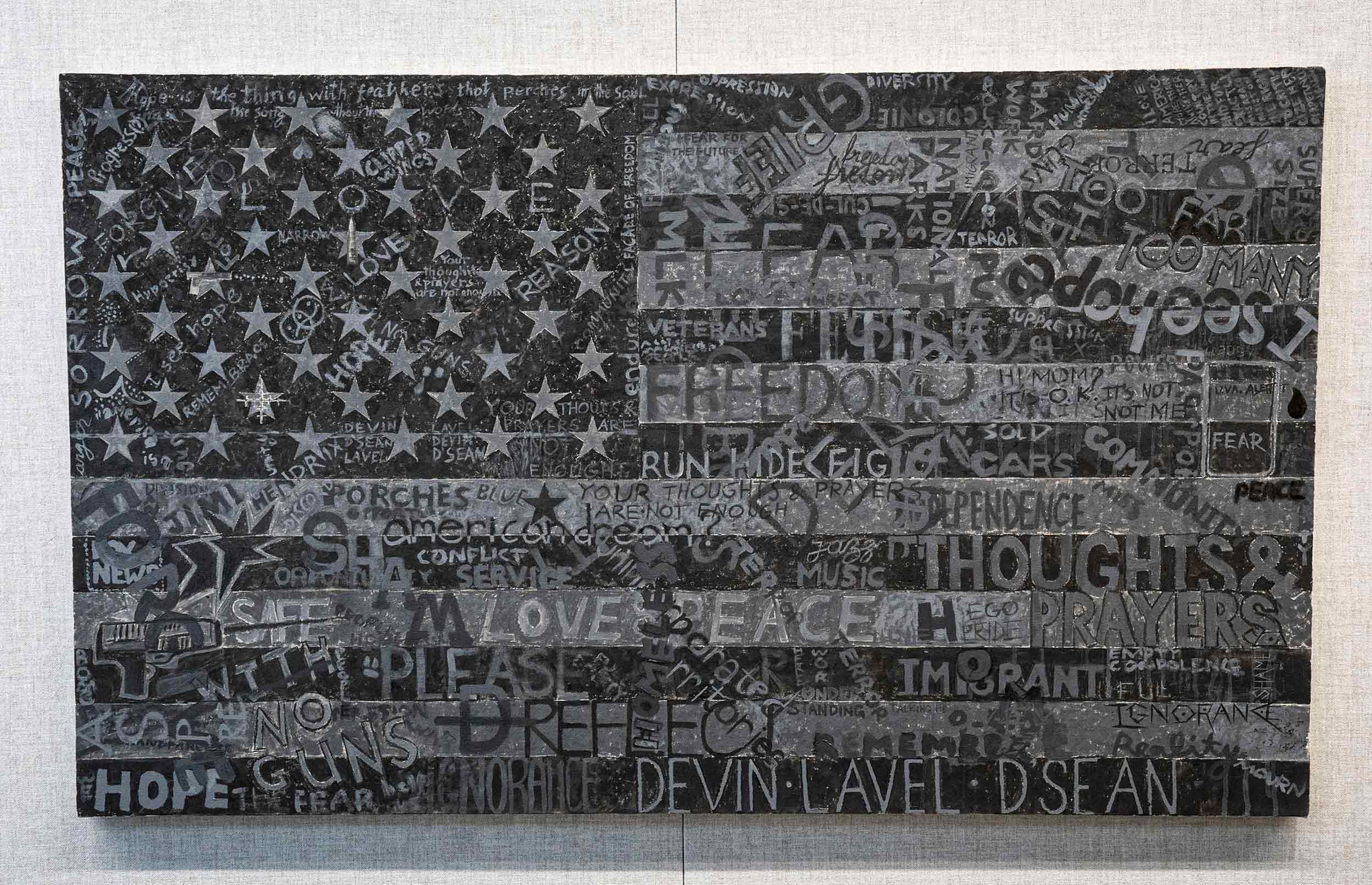 A close up of the "Dark Flag", the American flag in black and shades of grey with expressions written throughout 