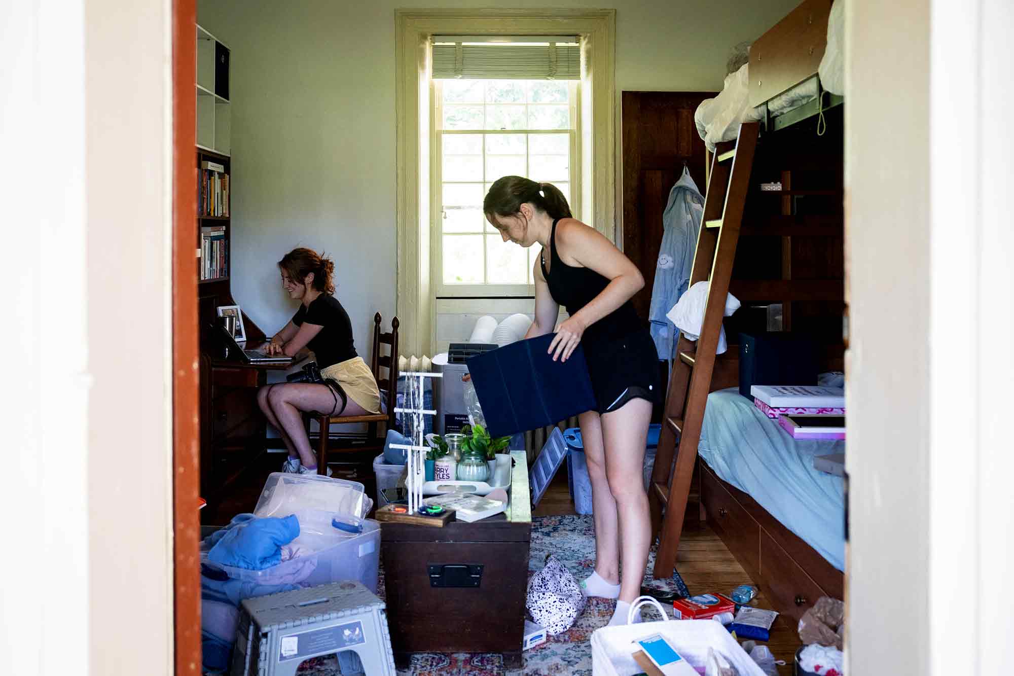 Two students unpack boxes in a Lawn Room