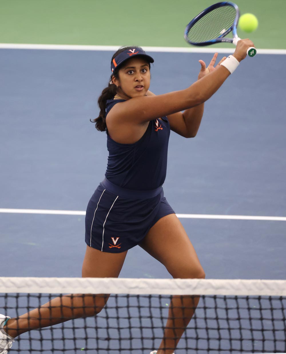 Action shot of Natasha Subhash swinging a tennis racket