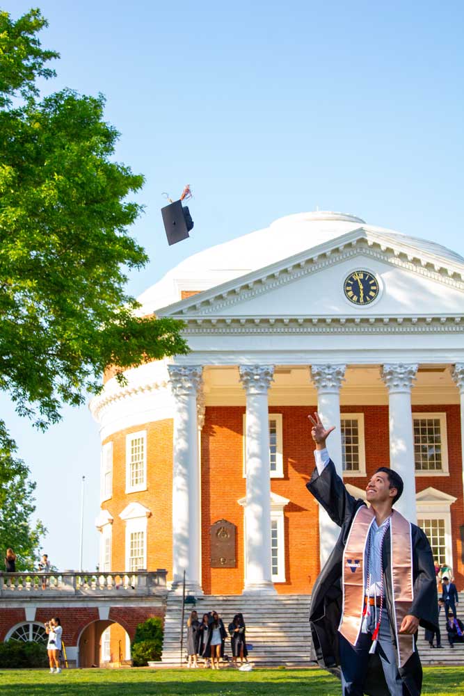 Abrishami-Azar throwing his cap up in front of the Rotunda for graduate pictures