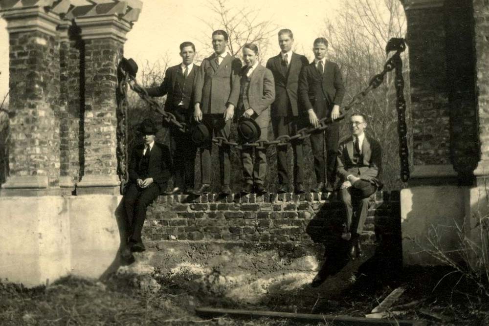 A group of male students on Grounds in suits