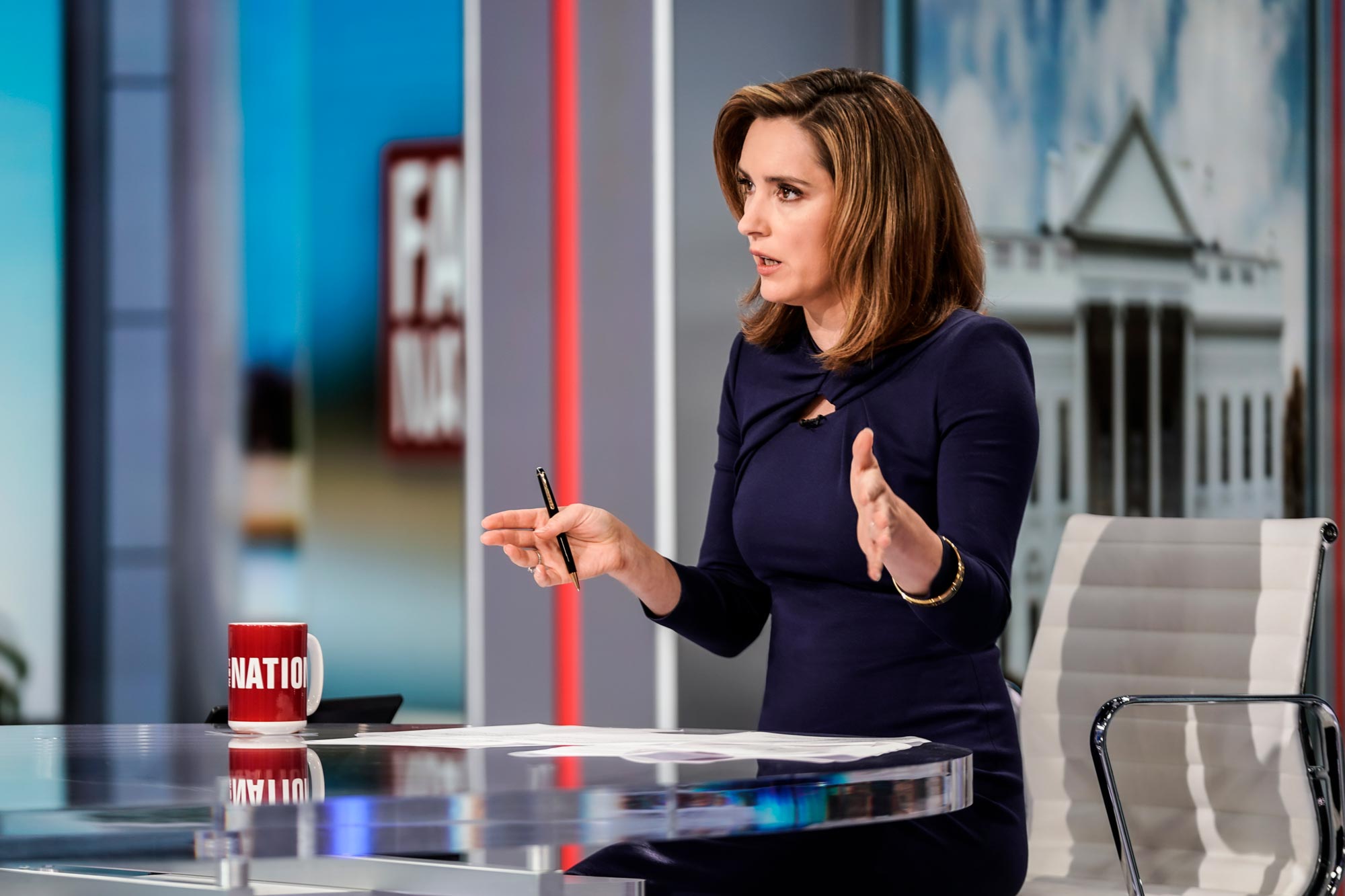 UVA alumna Margaret Brennan seated at a glass desk, talking on CBS News' Face the Nation