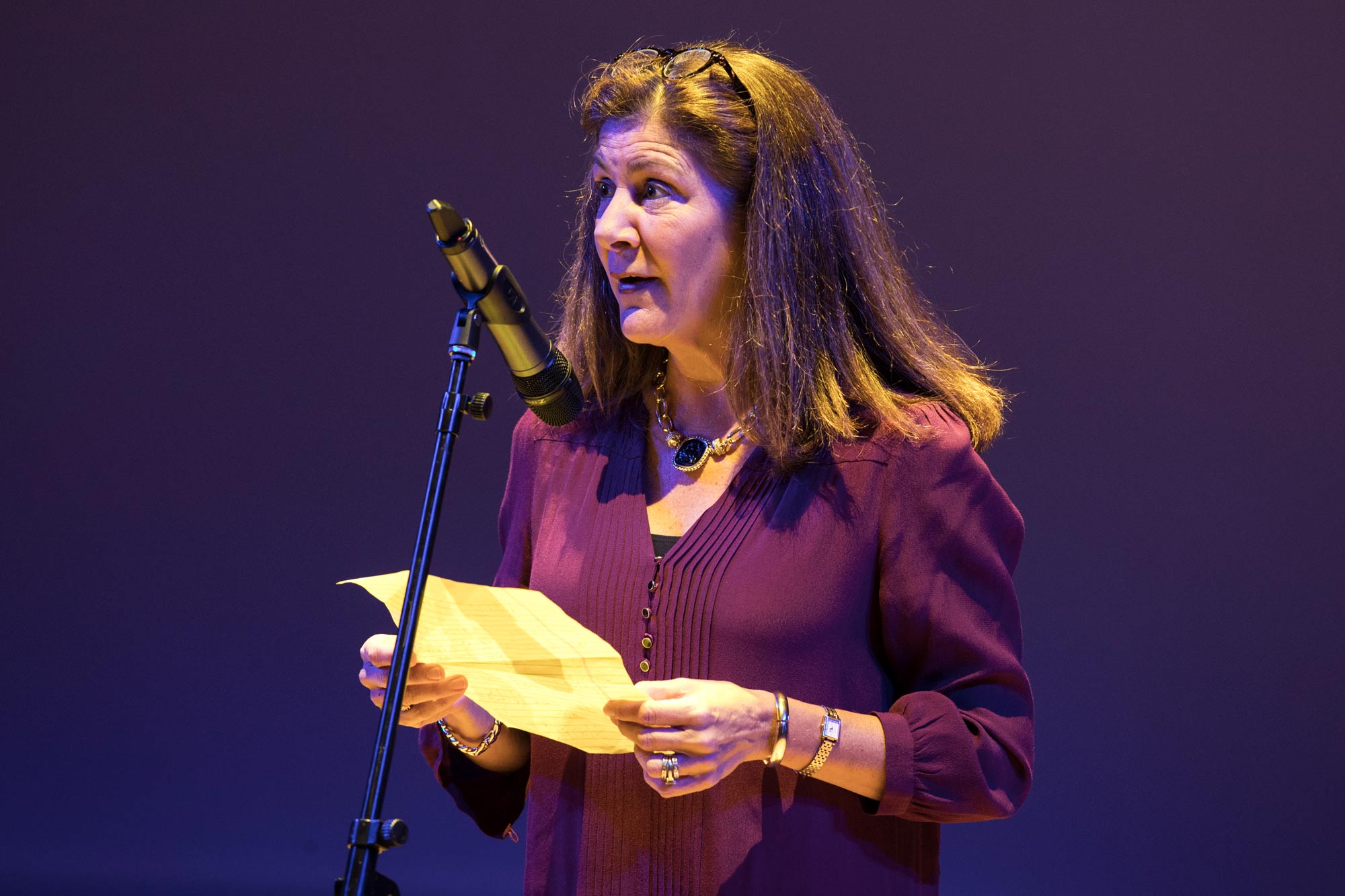 Sherri Moore holds a paper as she gives a speech into a microphone. 
