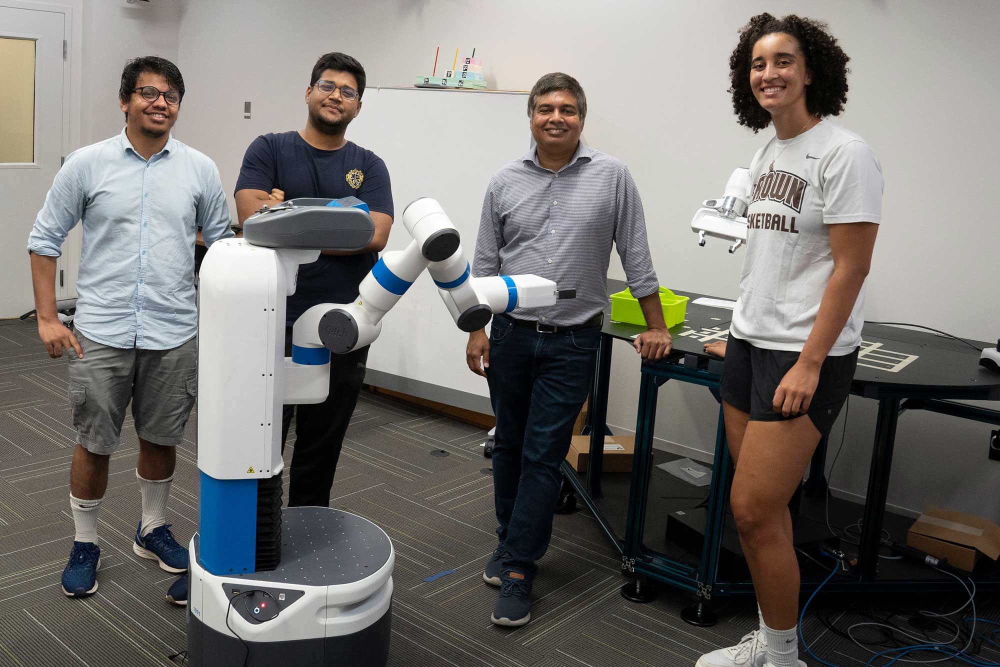 From left to right, Mohammad Samin Yasar, Sujan Sarker, Tariq Iqbal and Haley Green in the lab with a robot