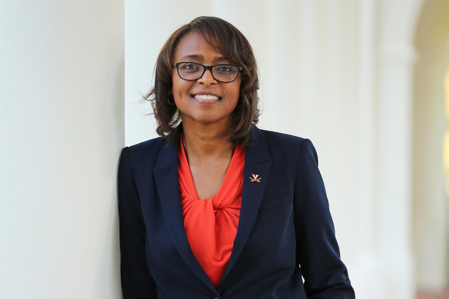 Carla Williams leans on a column, smiling