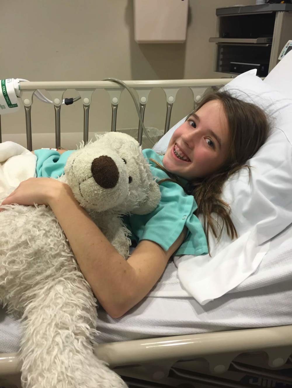 Hanley as a child in the hospital with a teddy bear