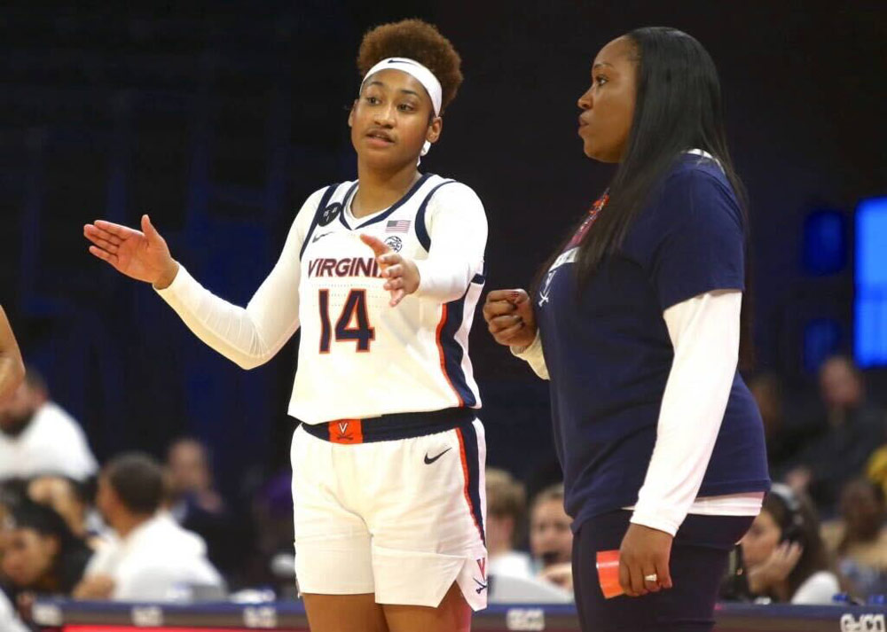 Amaka Agugua-Hamilton talking to a player on the sidelines during a game