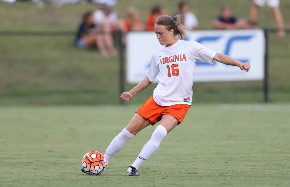 Emily Sonnett kicking a soccer ball during a game when she was a student at U V A