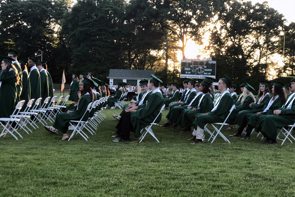 Soon-to-be graduates of Midland Park High School, sitting in rows listening to commencement ceremonies.