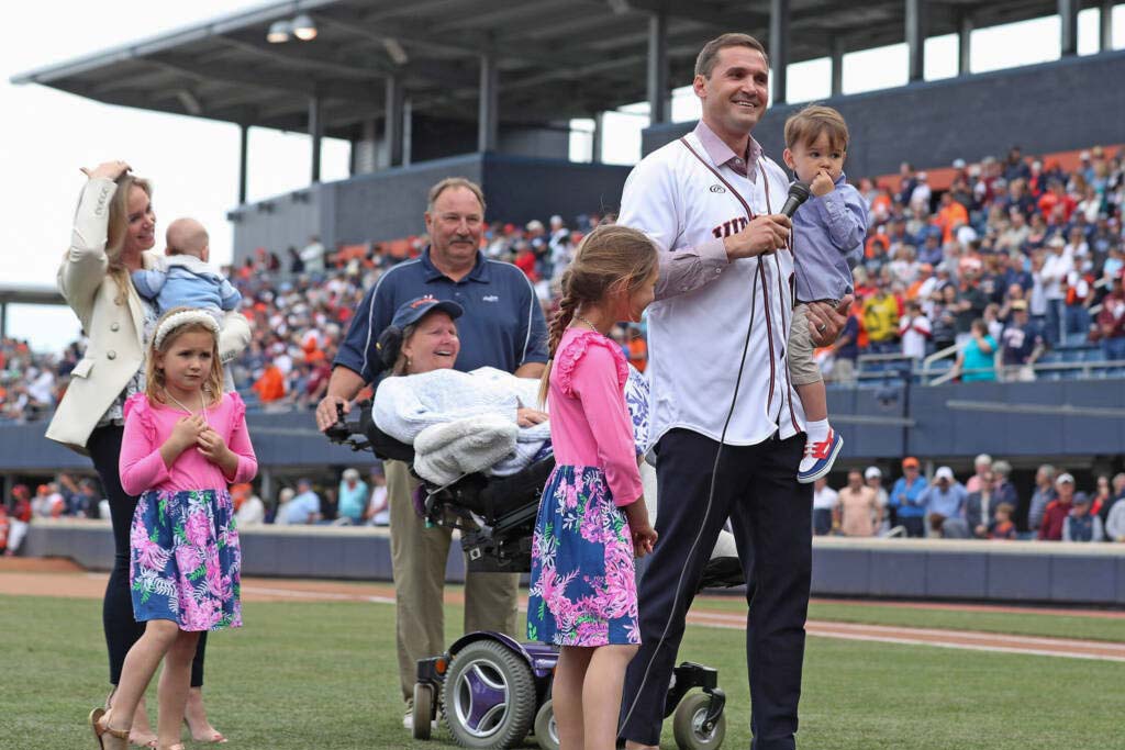 Ryan Zimmerman holds a microphone and his small son, among the rest of his family in the middle of the baseball field