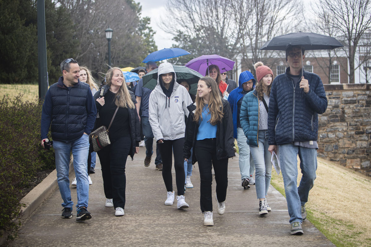 Tour meets on the sidewalk outside Peabody hall on a rainy day.