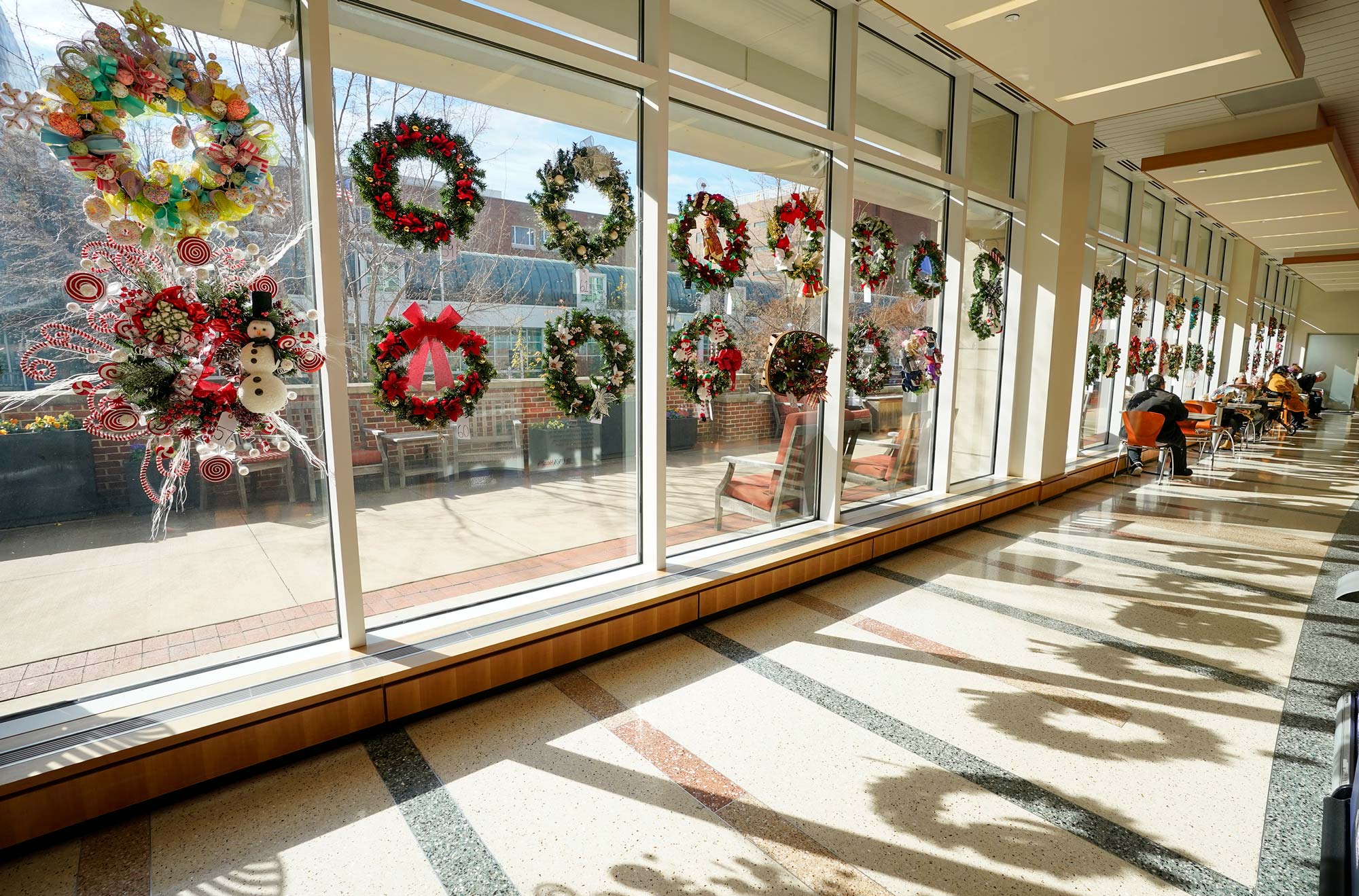 Wreaths for auction displayed down the windowed hallway