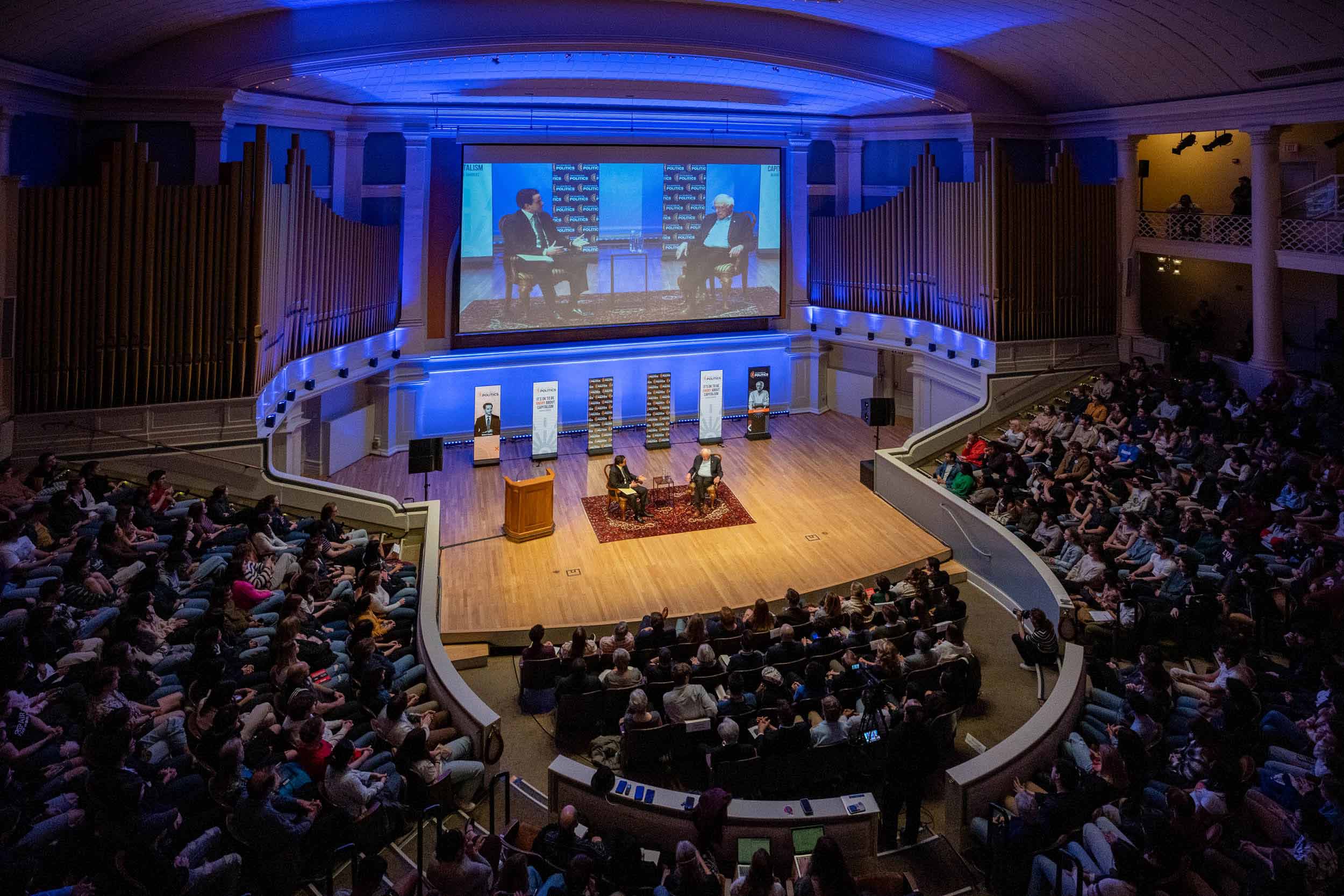 An overhead photo of the full audience in Old Cabell Hall while Bernie Sanders takes the stage.