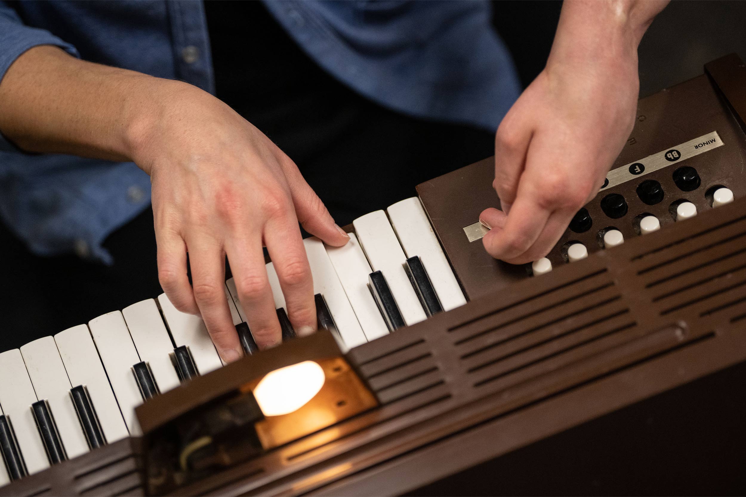 Close up of Joyce's hands playing her electric toy organ