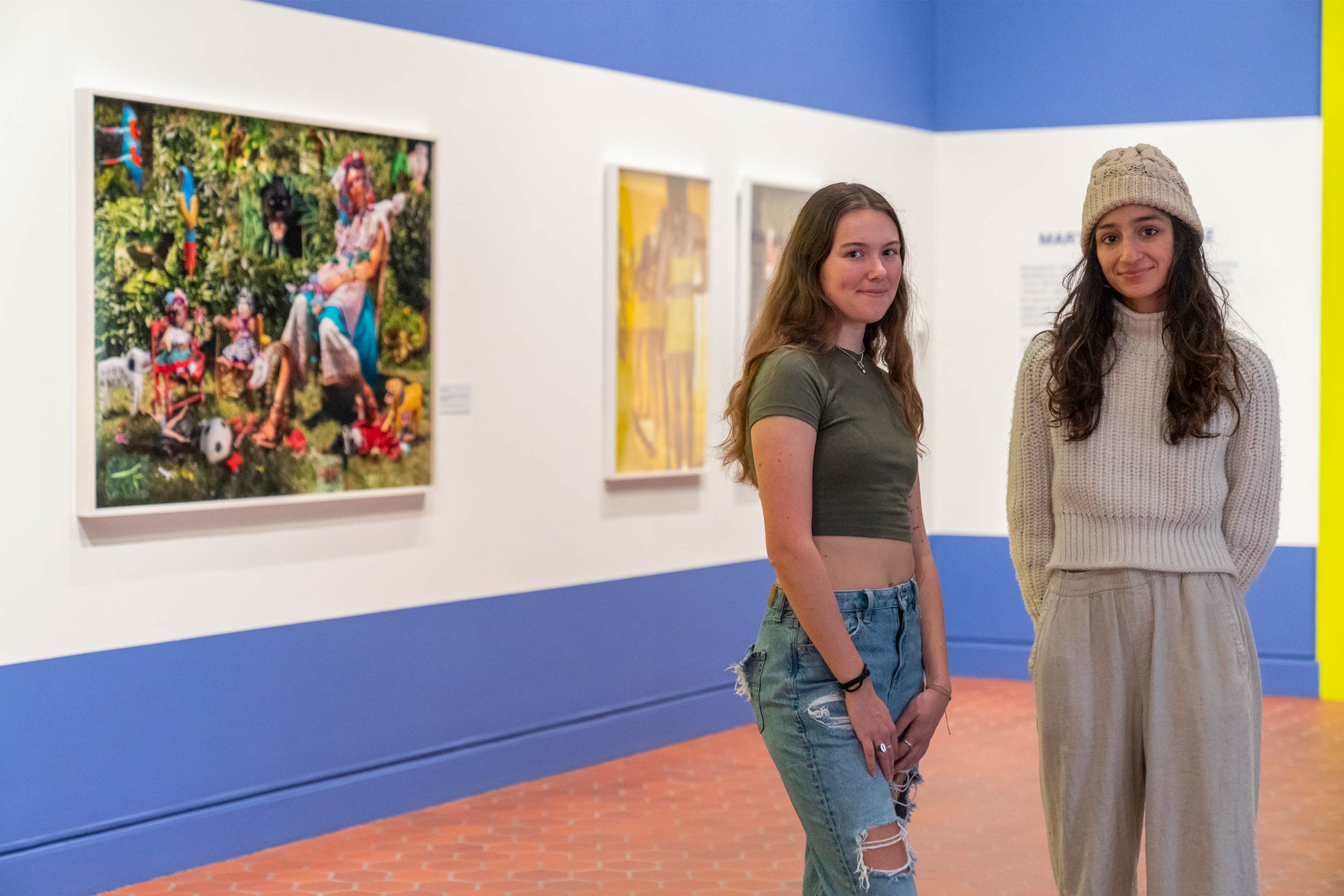 Ava Proehl, left, and Kate MacArthur, right stand in front of their art work smiling at the camera