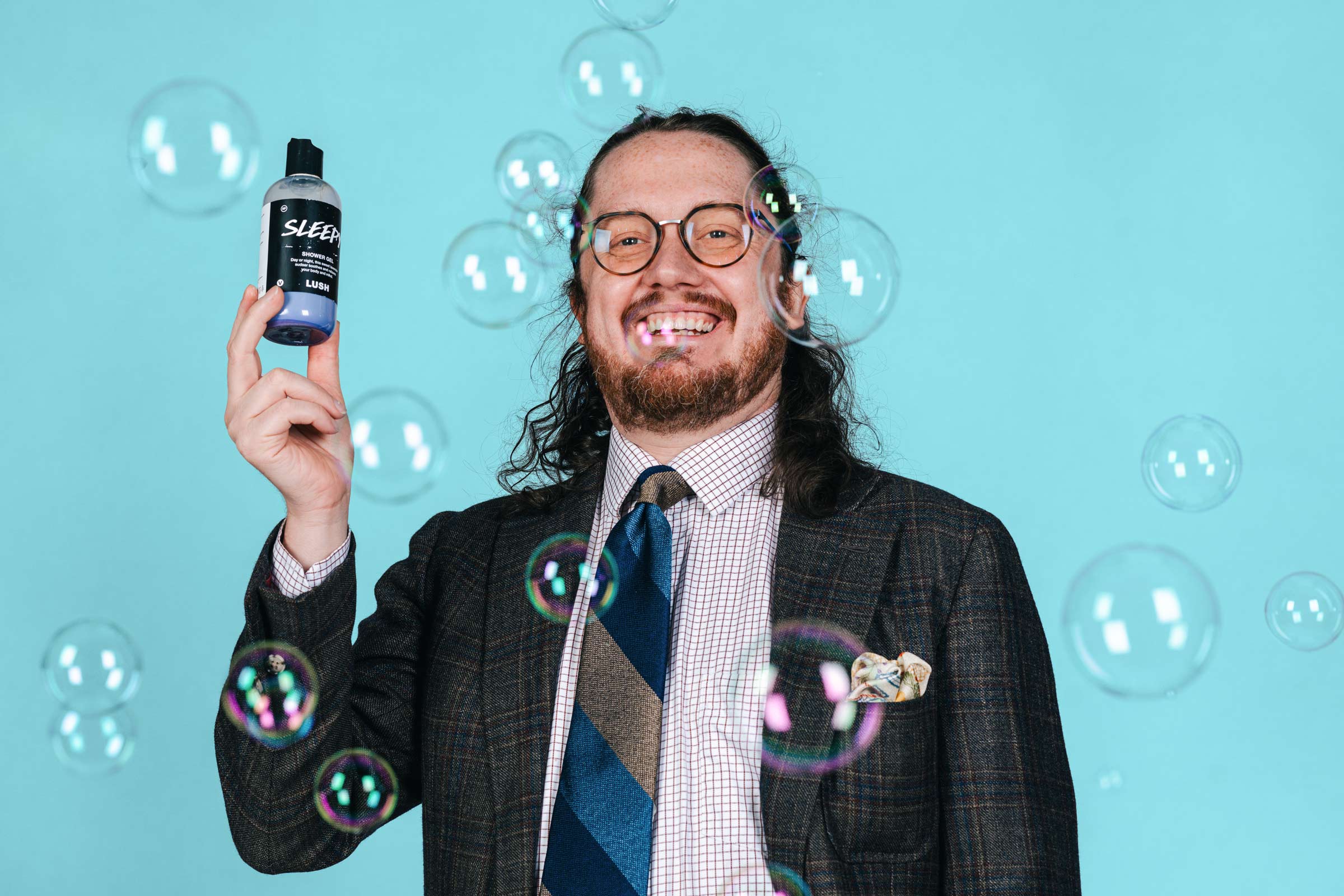 Irving holding a lush product surrounded by bubbles