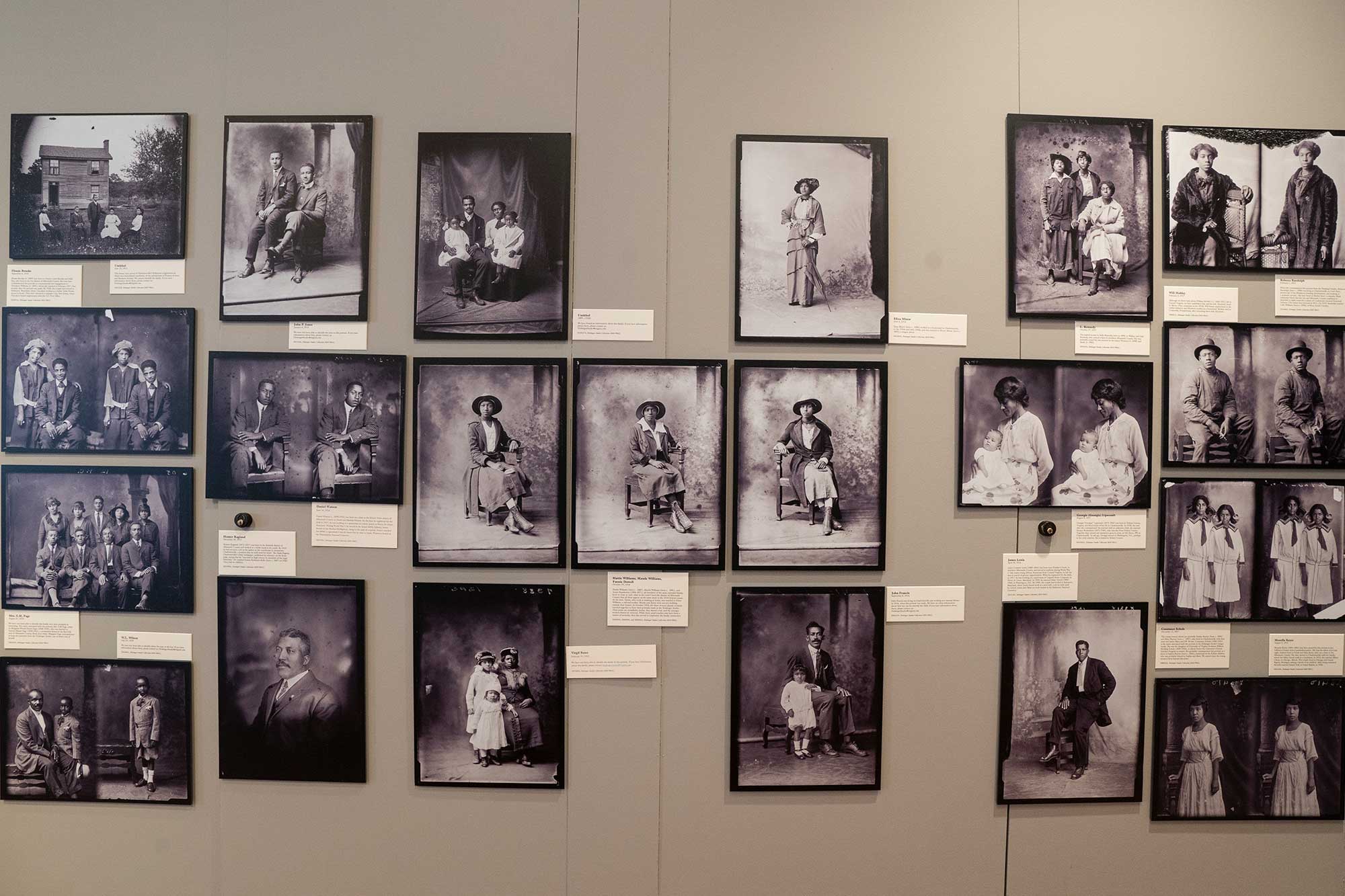 Dozens of black and white photos hang on a wall