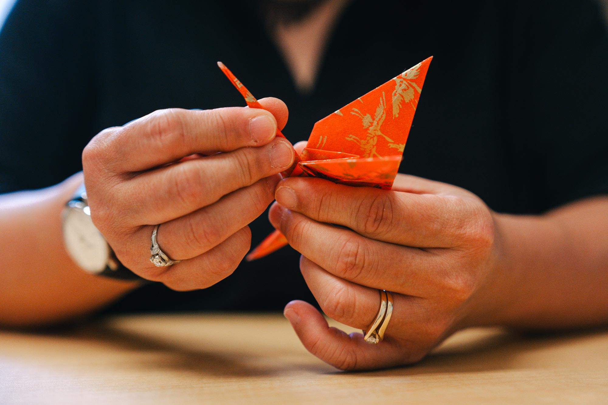 A close up of Professor Karen folding paper origami