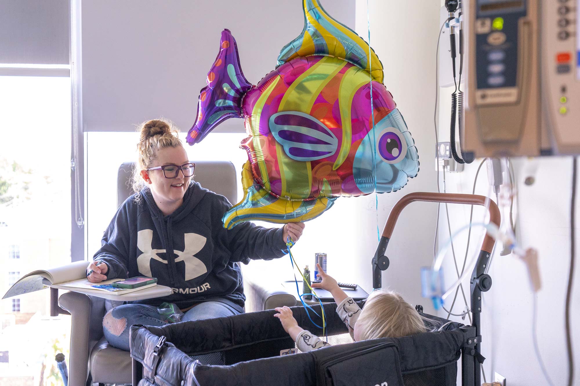 Miranda Lawhorne hands her daughter, Lorelai, a tropical fish balloon. 