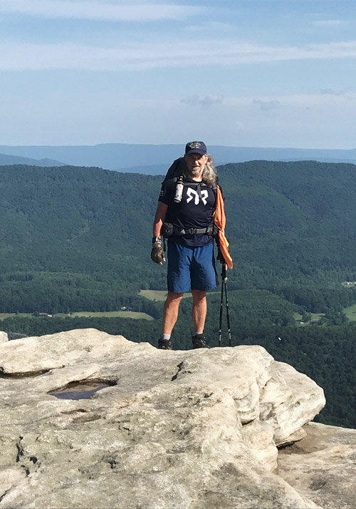 Tim Richard stands at the top of a mountain