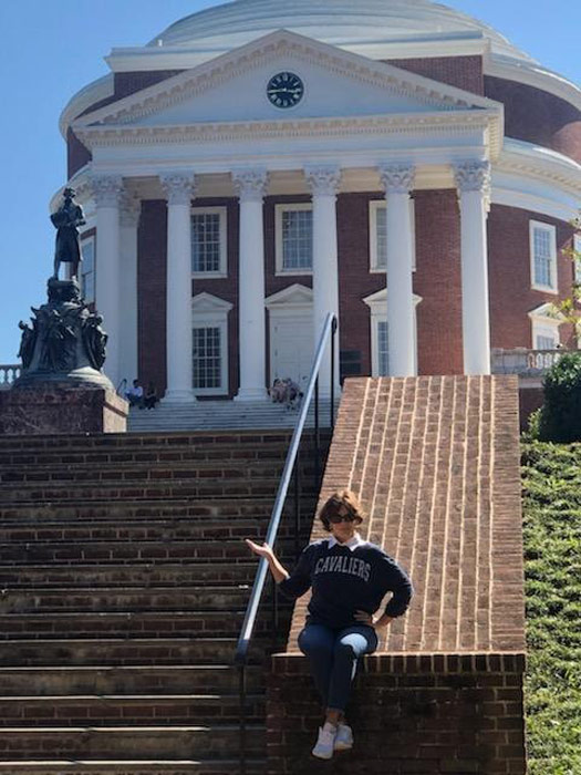 Jennifer Bowyer leans on the brick siding of the stairs outside of the Rotunda and Jefferson statue