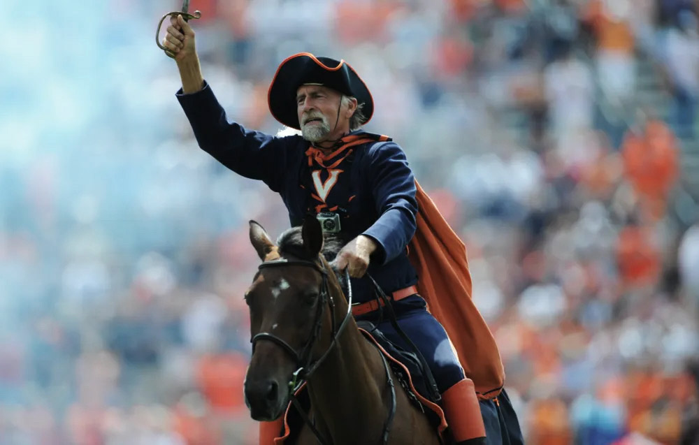 Kirschnick, riding through Scott Stadium on horseback, waves a saber.