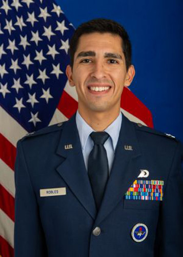 Tim Robles in uniform standing in front of an American flag