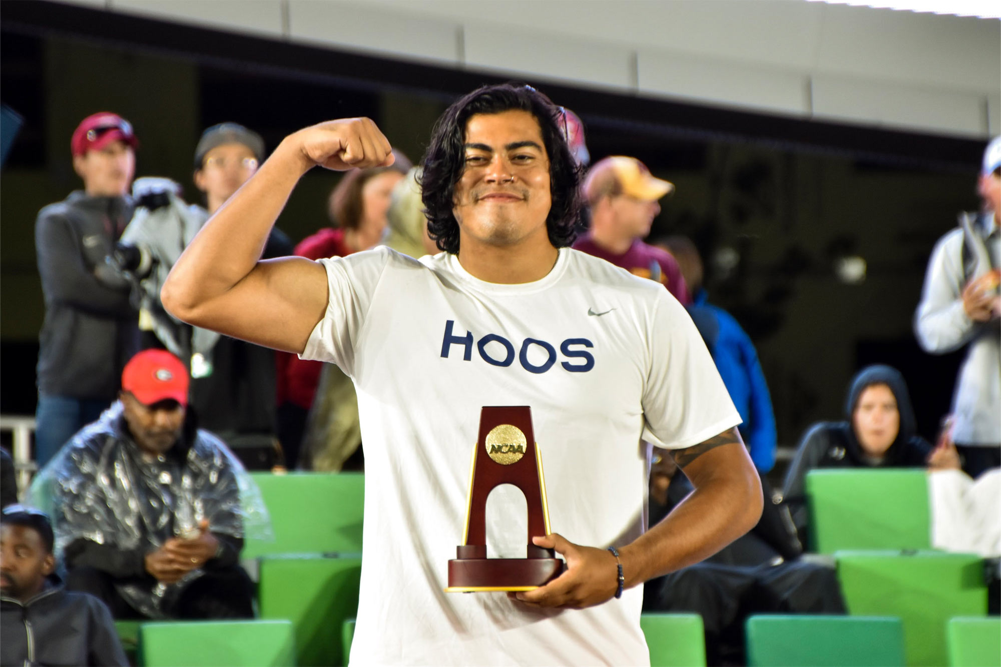 Romero holds the NCAA trophy and flexes his bicep