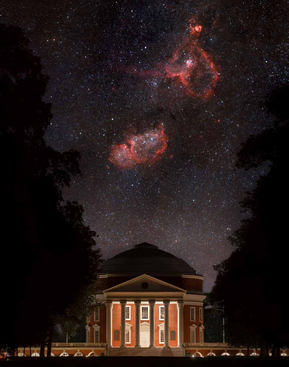 A cloudy, red nebula is visible in the starry night sky over the Rotunda