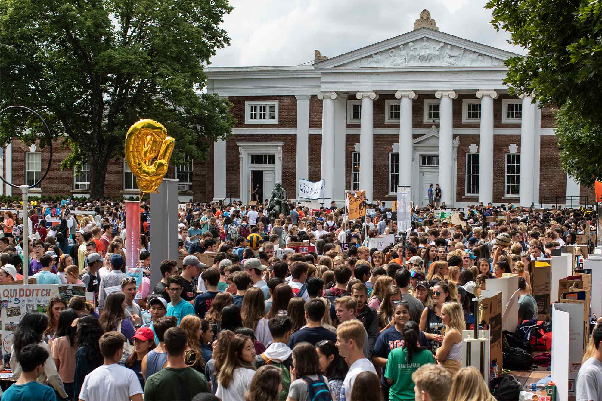 A large crowd of people fills the UVA Lawn in front of Old Cabell Hall