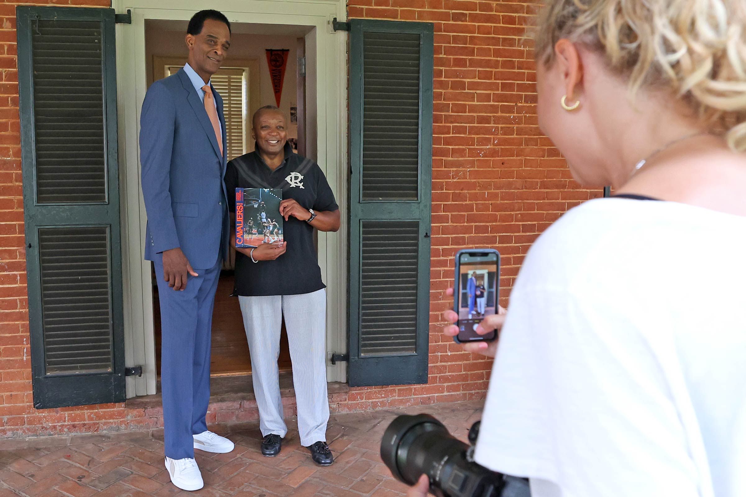 Cedric Rucker, UVA’s interim senior associate vice president for student affairs and dean of students, was a student during the Sampson era on Grounds. Upon learning of the Sampson shoot, he brought an old UVA basketball photo book for Sampson to sign. 