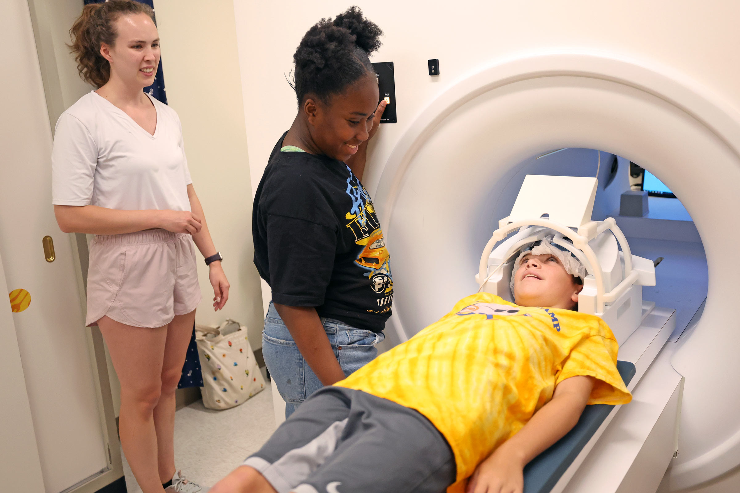 Student assisting kid in an MRI