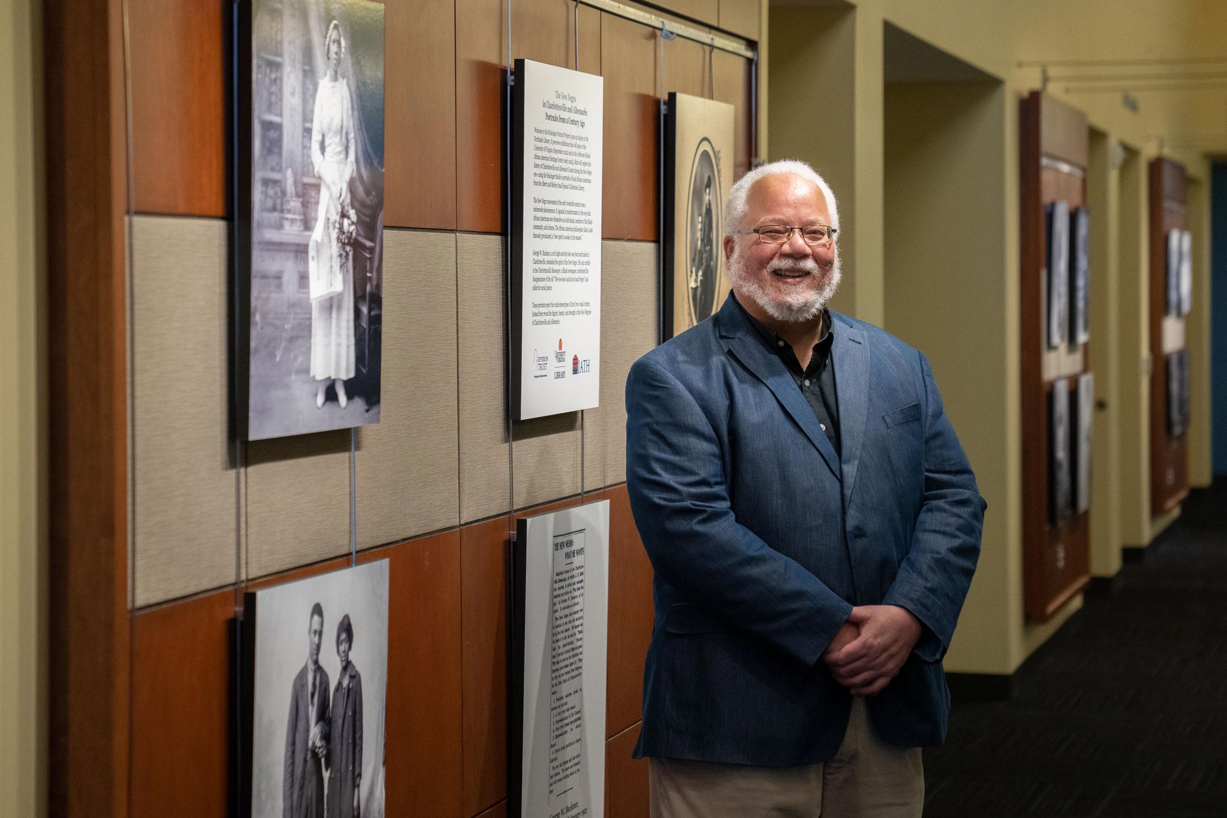 University of Virginia professor John Edwin Mason smiles in front of a section of the exhibit.