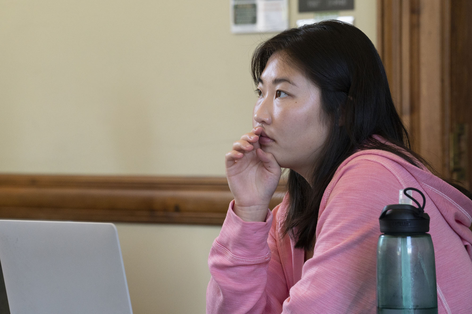 Seated at a desk, Victoria Kim looks forward over her laptop