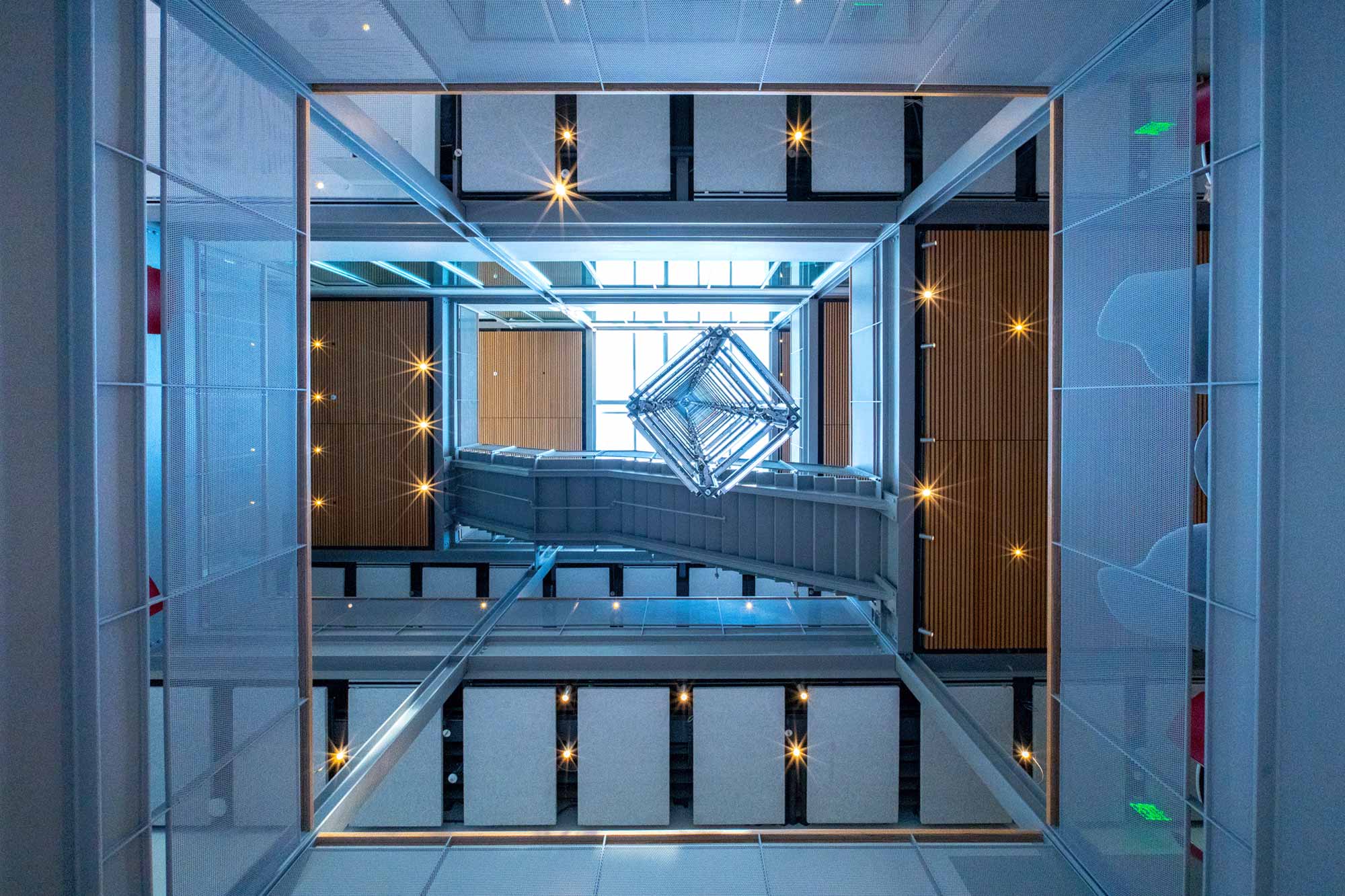 A geometrical and blue view looking up through the building