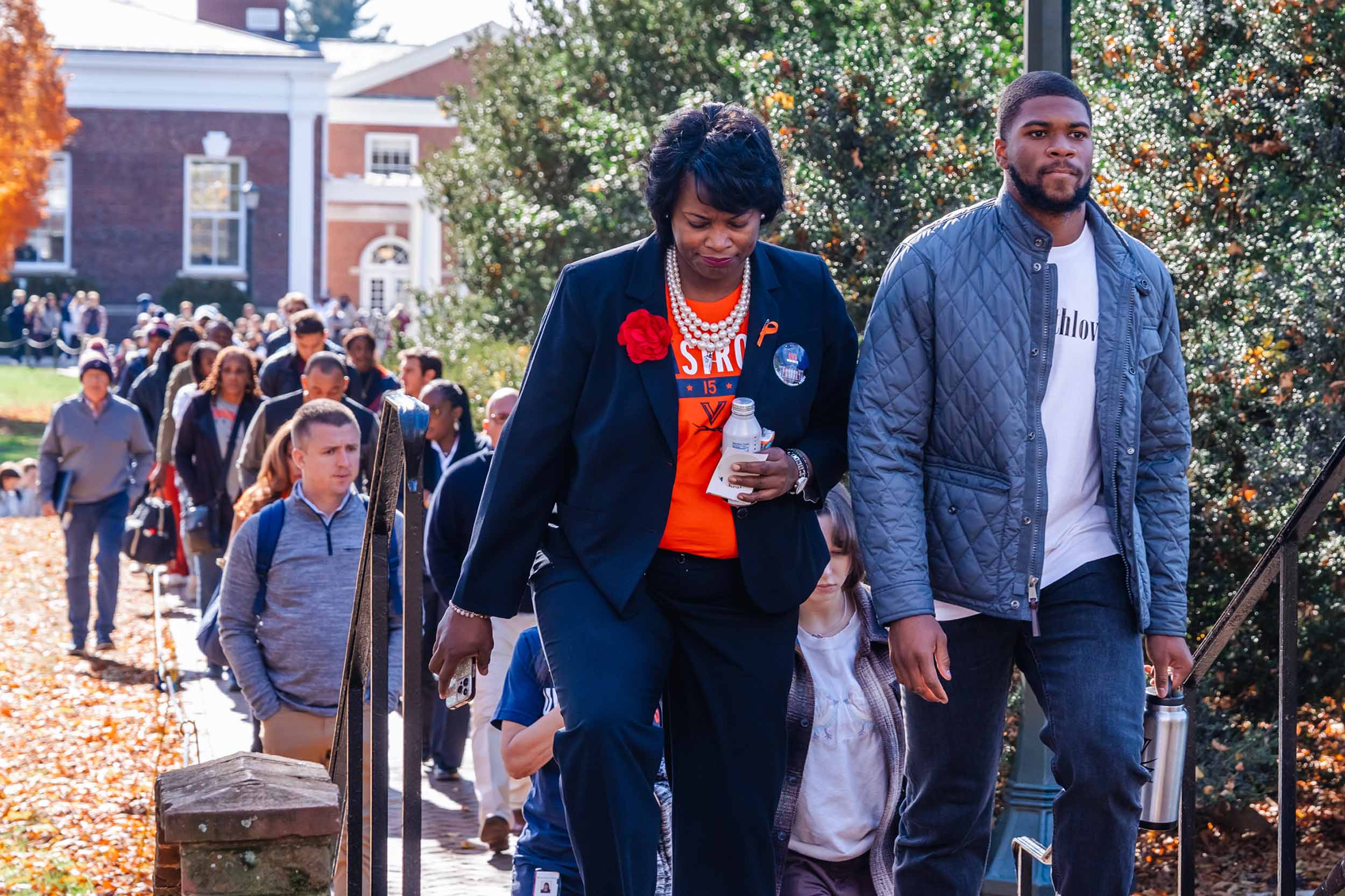 Tracy Walls and Chico Bennett Jr. walking from Old Cabell Hall towards the UVA Chapel with a line of students behind them