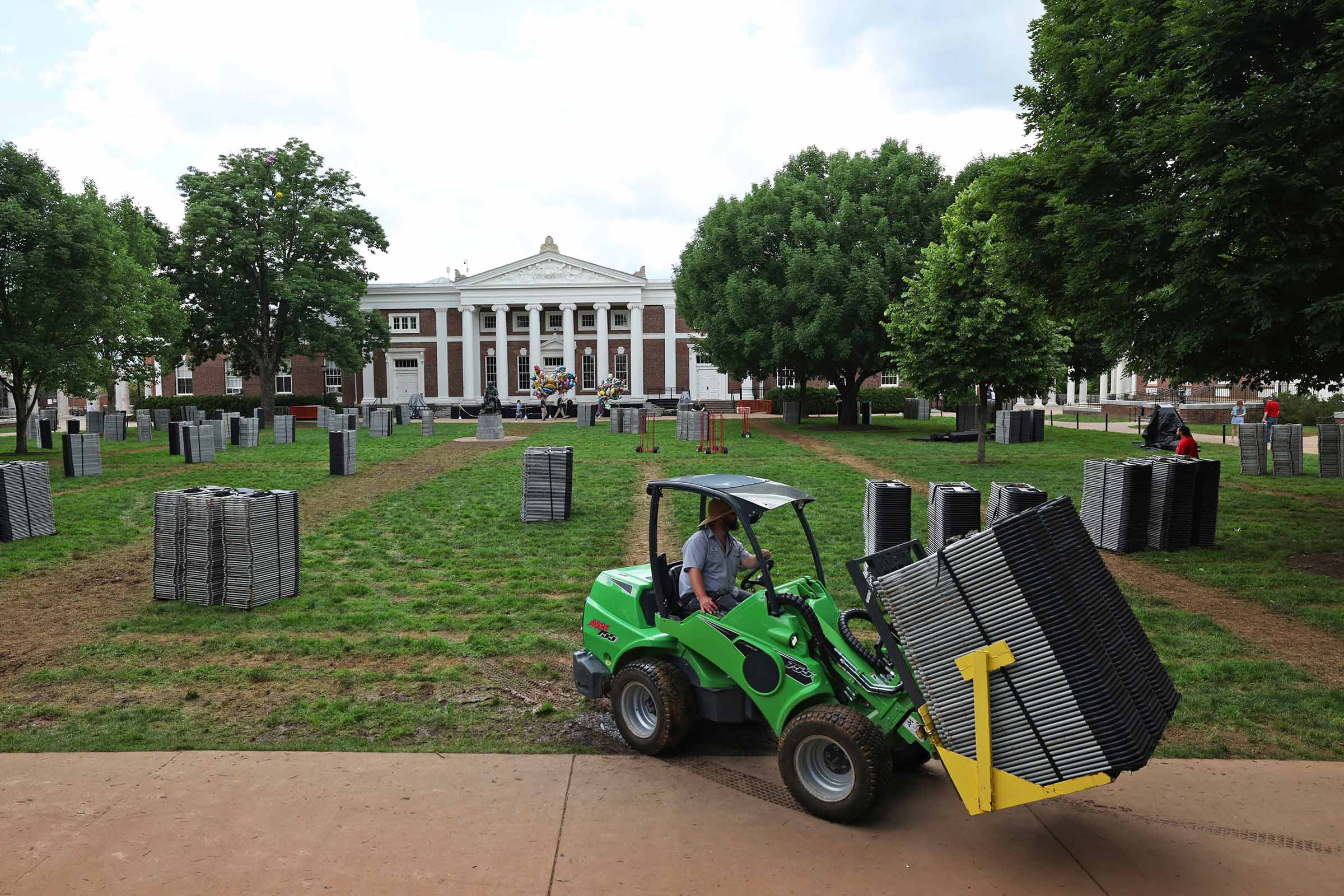 Landscapers stacked chairs and used tractors to move them off the Lawn, the first step in repairing the grass for the upcoming Reunions Weekend. )