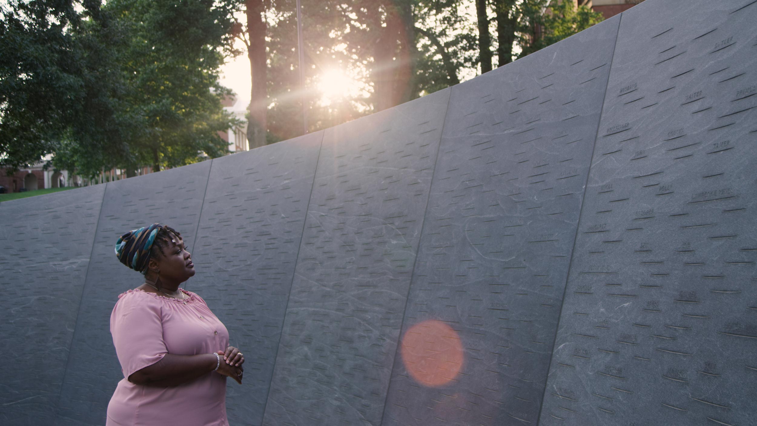Woman looking at the Memorial of Enslaved Laborers wall