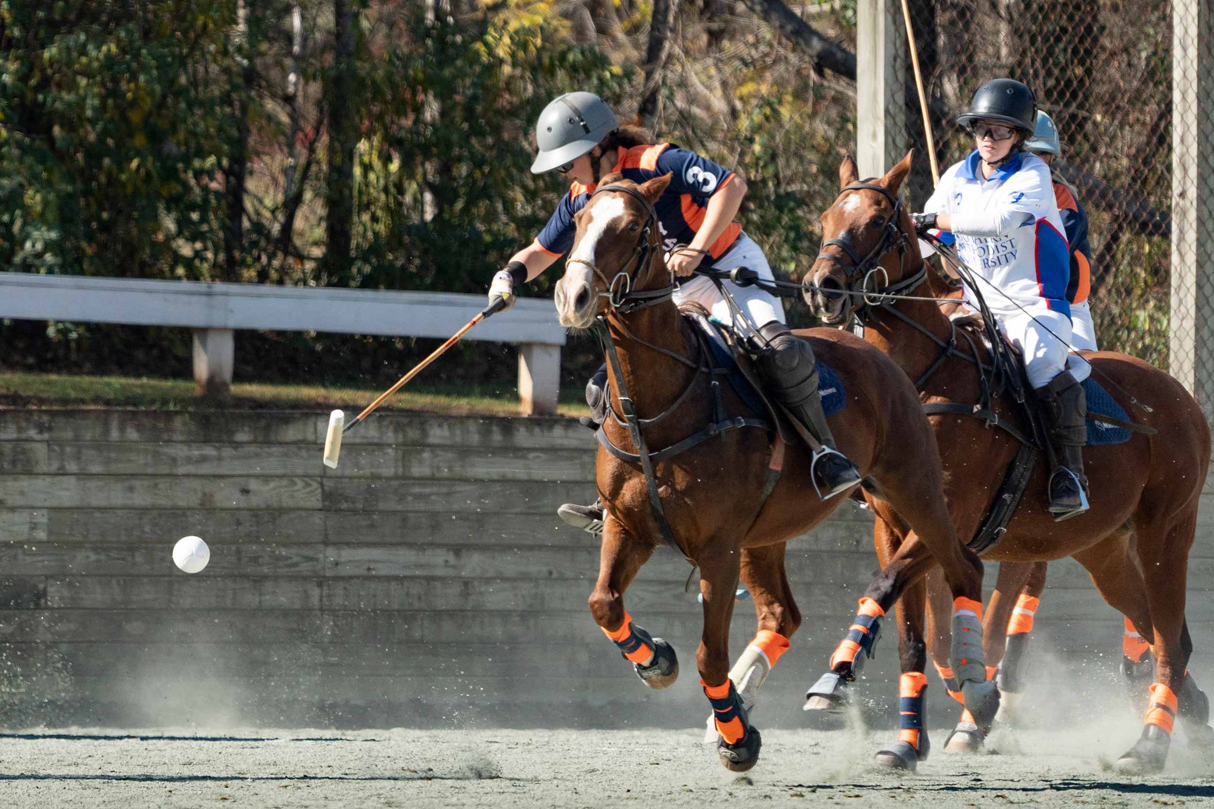 UVA polo player hitting a ball while her horse is in full gallop