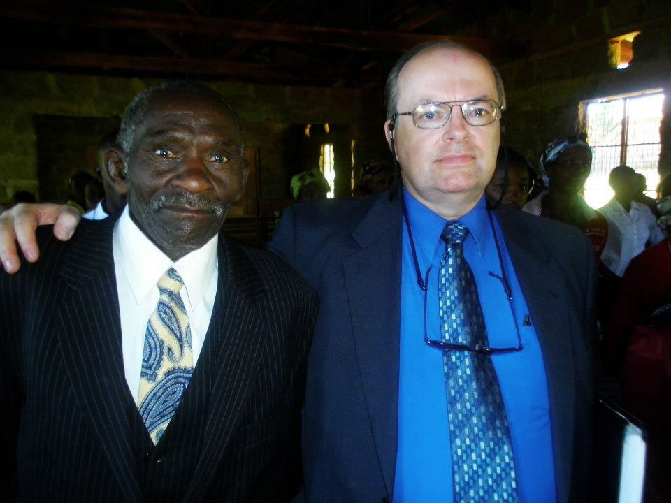 Two men in suits look solemnly at the camera