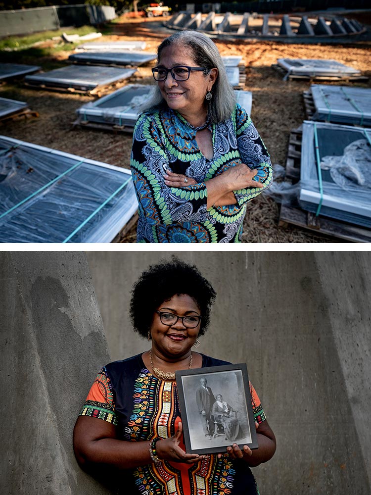 Shelley Murphy stands smiling with her arms crossed in a field with stacks of portraits on pallets, and DeTeasa Gathers holds a small framed black and white portrait