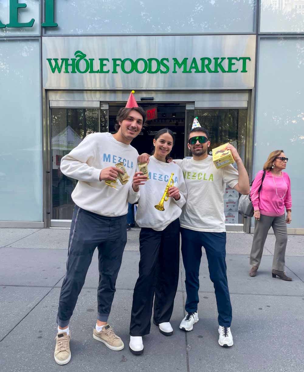 Griffin Spolansky standing outside a Whole Foods with Mezcla bars and a couple friends