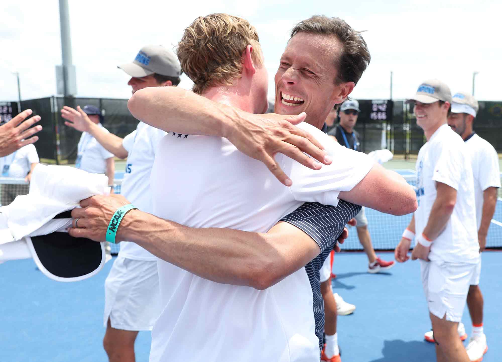 Head coach embraces tennis player in celebration